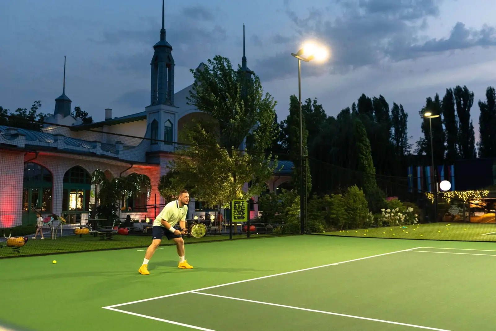 Outdoor tennis courts at Villa Sandy City Park Resort lit for evening play